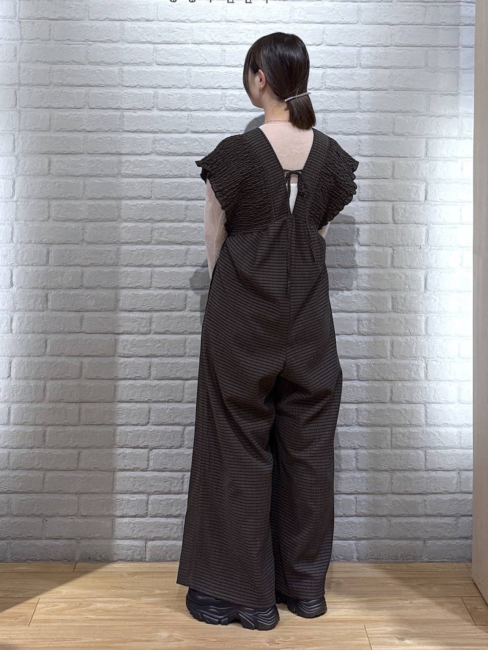 ブラウン系のサロペット/オーバーオール、ホワイト系のボストンバッグ、ブラック系のローファーを着用したレディースの春コーディネートの3枚目の写真