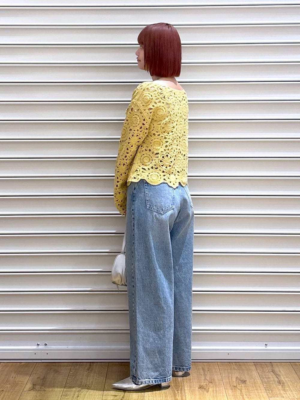 ブルー系のデニムパンツ、ゴールド系のタンクトップ、シルバー系のトートバッグを着用したレディースの春コーディネートの3枚目の写真