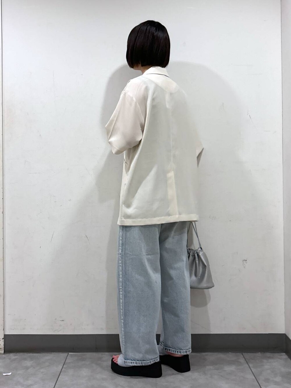 シルバー系のサンダル、ホワイト系のショルダーバッグ、ブラック系のタンクトップを着用したレディースの夏コーディネートの3枚目の写真