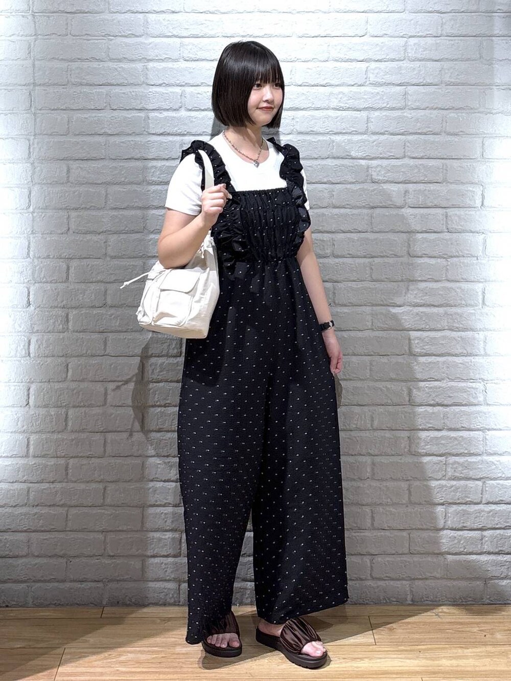 ホワイト系のTシャツ/カットソー、ブラウン系のサンダル、ホワイト系のショルダーバッグを着用したレディースの夏コーディネートの2枚目の写真