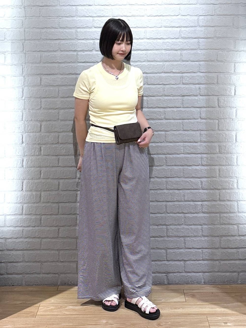イエロー系のTシャツ/カットソー、ホワイト系のその他パンツ、ホワイト系のサンダルを着用したレディースの夏コーディネートの2枚目の写真