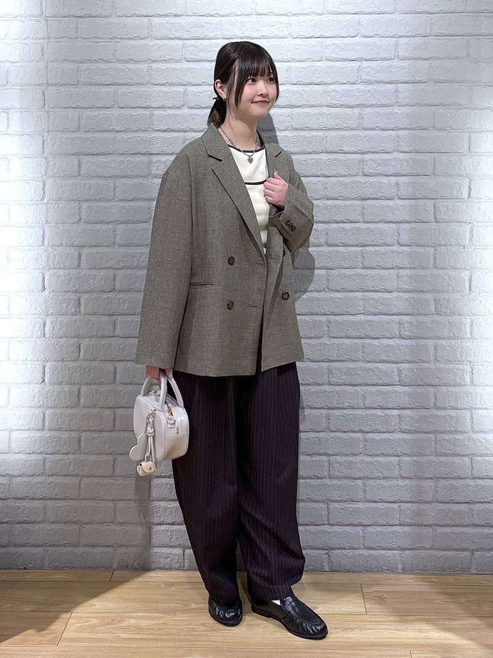 ブラウン系のその他パンツ、ブラウン系のテーラードジャケット、ホワイト系のボストンバッグを着用したレディースの春コーディネートの2枚目の写真