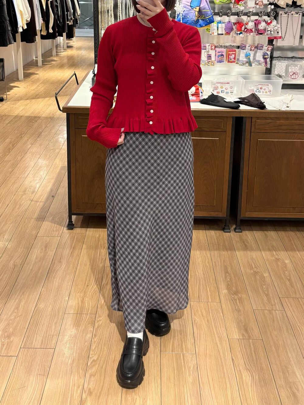 ブラック系のローファー、レッド系のTシャツ/カットソー、グレー系のスカートを着用したレディースの冬コーディネートの3枚目の写真