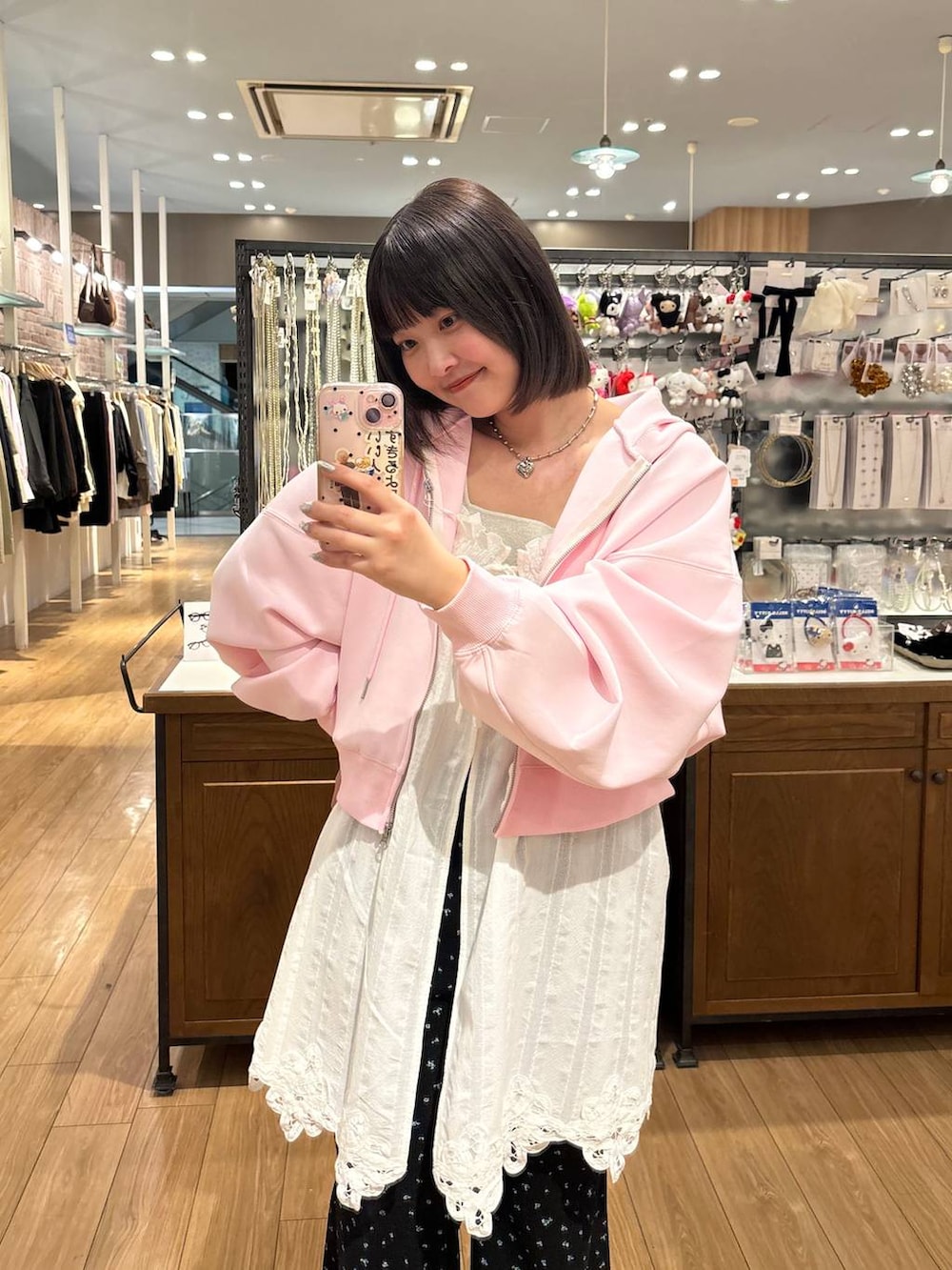 シルバー系のタンクトップ、ピンク系のパーカー、ホワイト系のパンプスを着用したレディースの春コーディネートの2枚目の写真