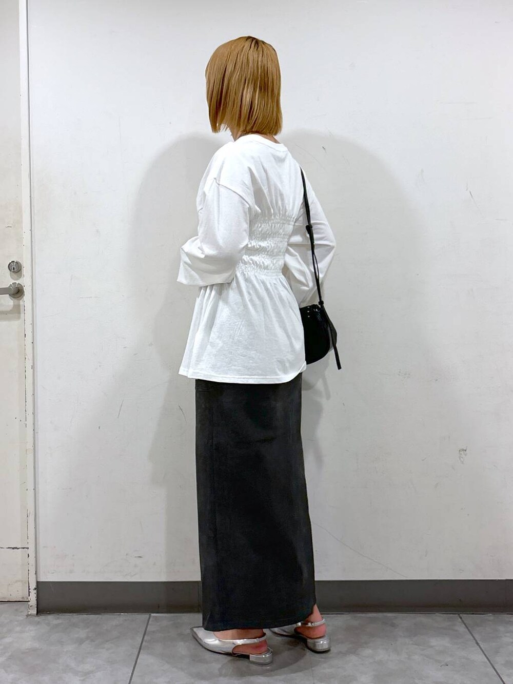 シルバー系のパンプス、ブラック系のショルダーバッグ、グレー系のスカートを着用したレディースの秋コーディネートの3枚目の写真