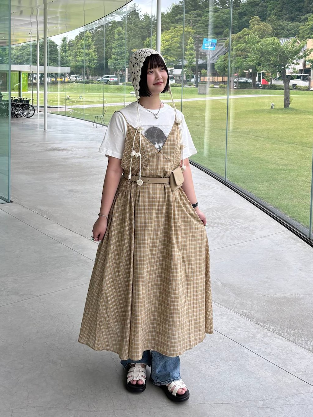 ホワイト系のサンダル、イエロー系のワンピース、ホワイト系のTシャツ/カットソーを着用したレディースの夏コーディネートの3枚目の写真