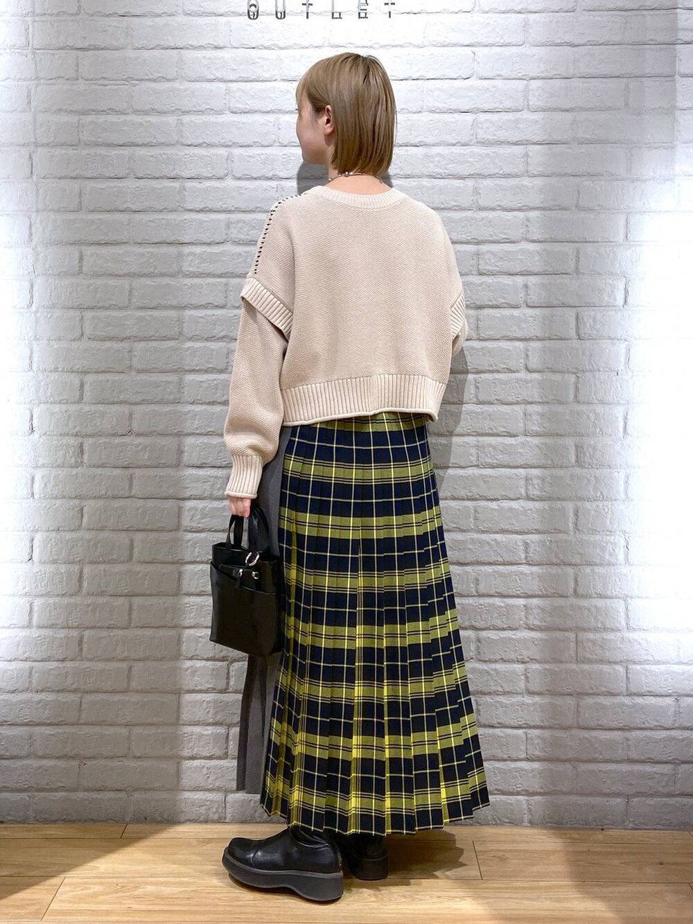 ホワイト系のTシャツ/カットソー、ブラック系のブーツ、ブラック系のショルダーバッグを着用したレディースの冬コーディネートの3枚目の写真