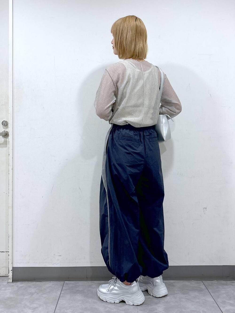 ブルー系のカーゴパンツ、シルバー系のショルダーバッグ、ホワイト系のタンクトップを着用したレディースの夏コーディネートの3枚目の写真