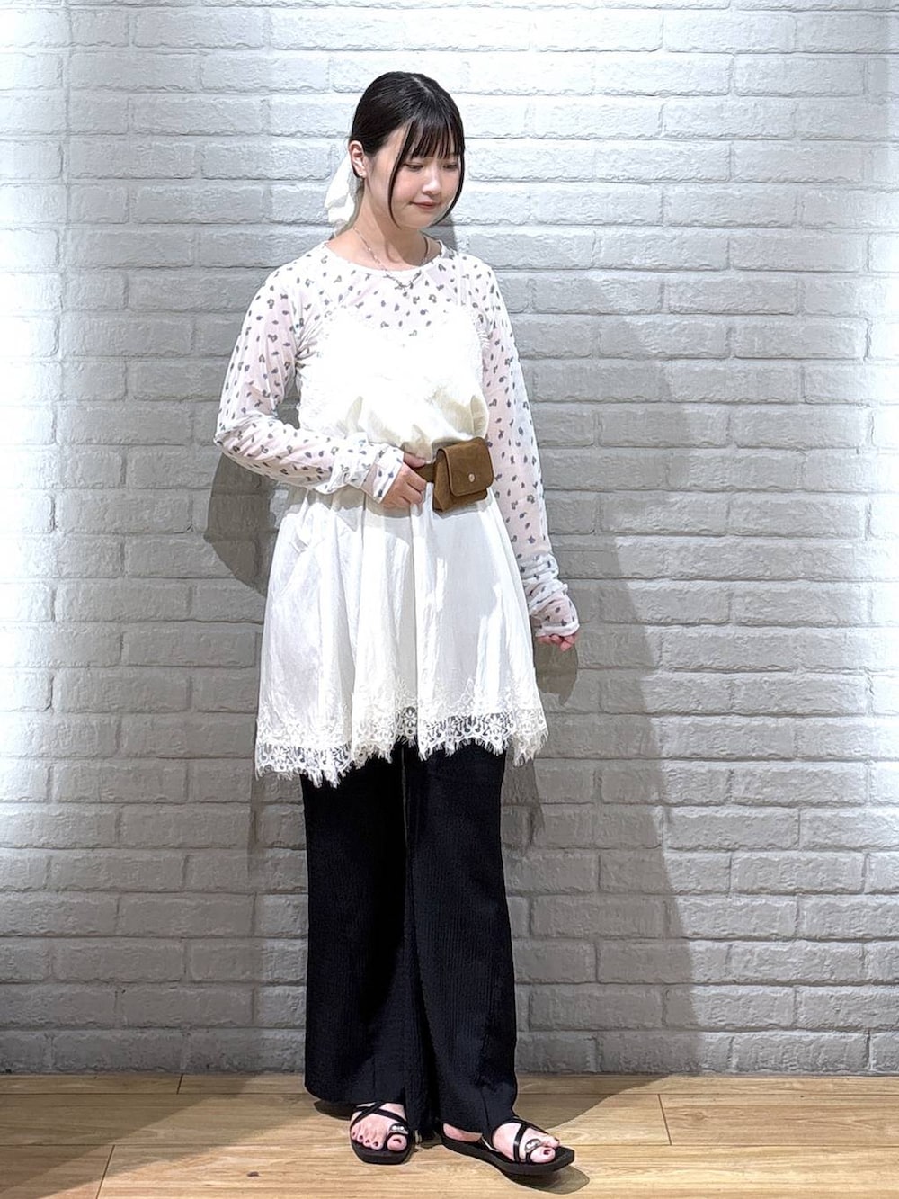 ホワイト系のTシャツ/カットソー、ブラック系のサンダル、ブラック系のその他パンツを着用したレディースの秋コーディネートの2枚目の写真