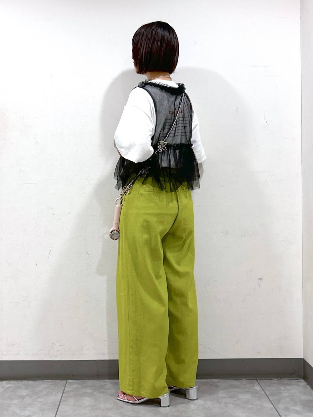 シルバー系のサンダル、グリーン系のスラックス、ホワイト系のTシャツ/カットソーを着用したレディースの夏コーディネートの3枚目の写真