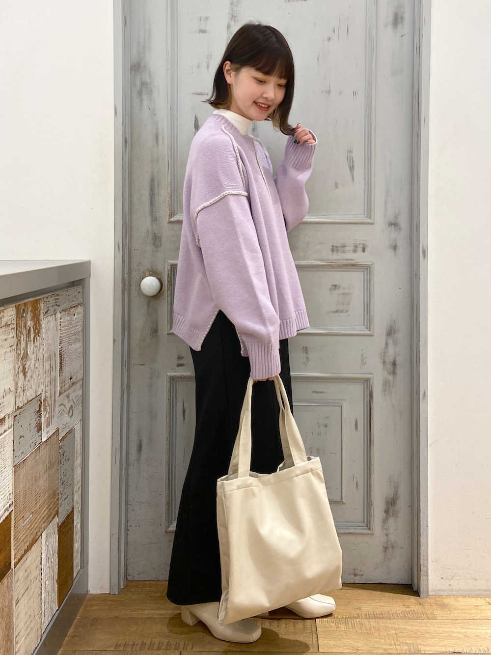 パープル系のニット/セーター、ホワイト系のTシャツ/カットソー、ブラック系のスカートを着用したレディースの冬コーディネートの2枚目の写真