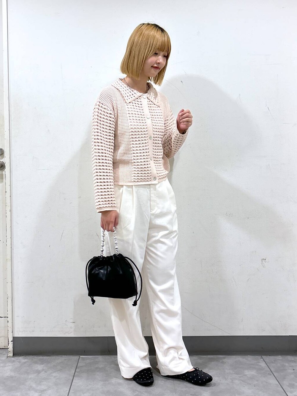 ホワイト系のスラックス、ブラック系のショルダーバッグ、ブラック系のバレエシューズを着用したレディースの秋コーディネートの2枚目の写真