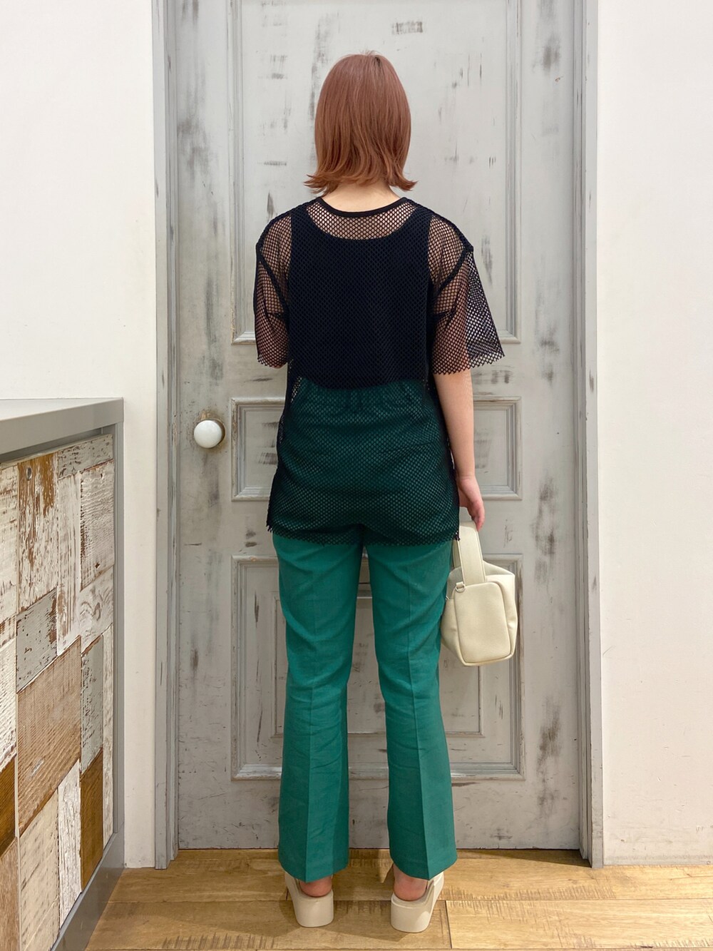 ブラック系のTシャツ/カットソー、ブラック系のタンクトップ、グリーン系のスラックスを着用したレディースの春コーディネートの3枚目の写真