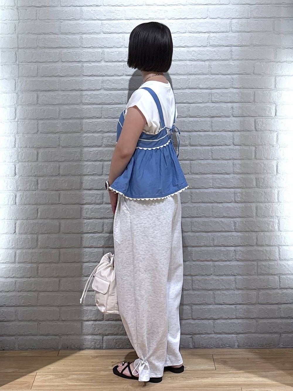 ホワイト系のTシャツ/カットソー、グレー系のスウェットパンツ、ブラック系のサンダルを着用したレディースの夏コーディネートの3枚目の写真