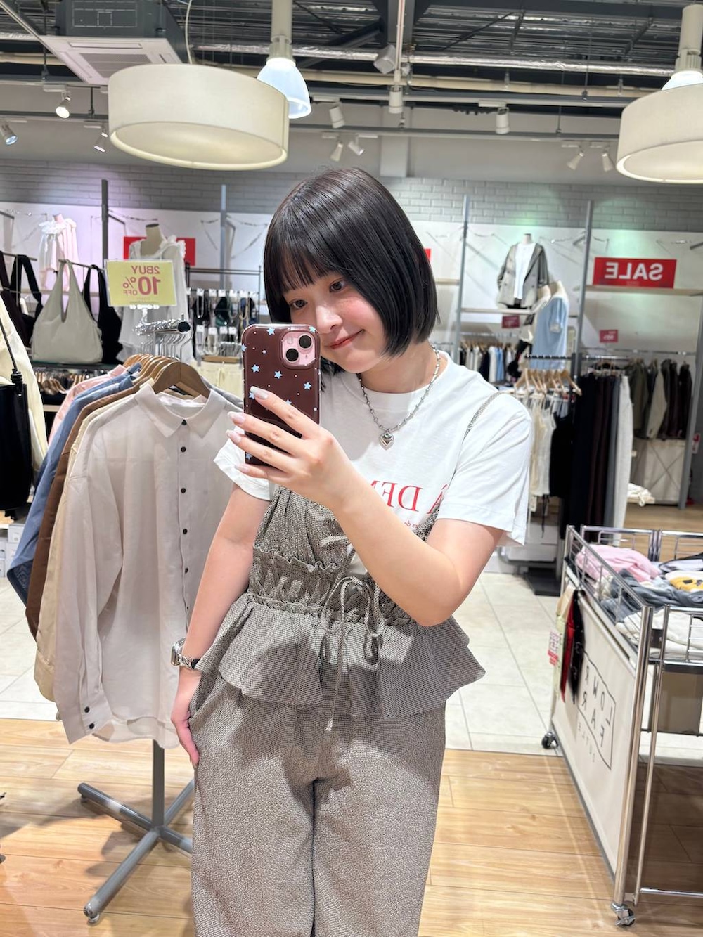 ブラック系のパンプス、ホワイト系のTシャツ/カットソー、ブラウン系のサロペット/オーバーオールを着用したレディースの春コーディネートの2枚目の写真