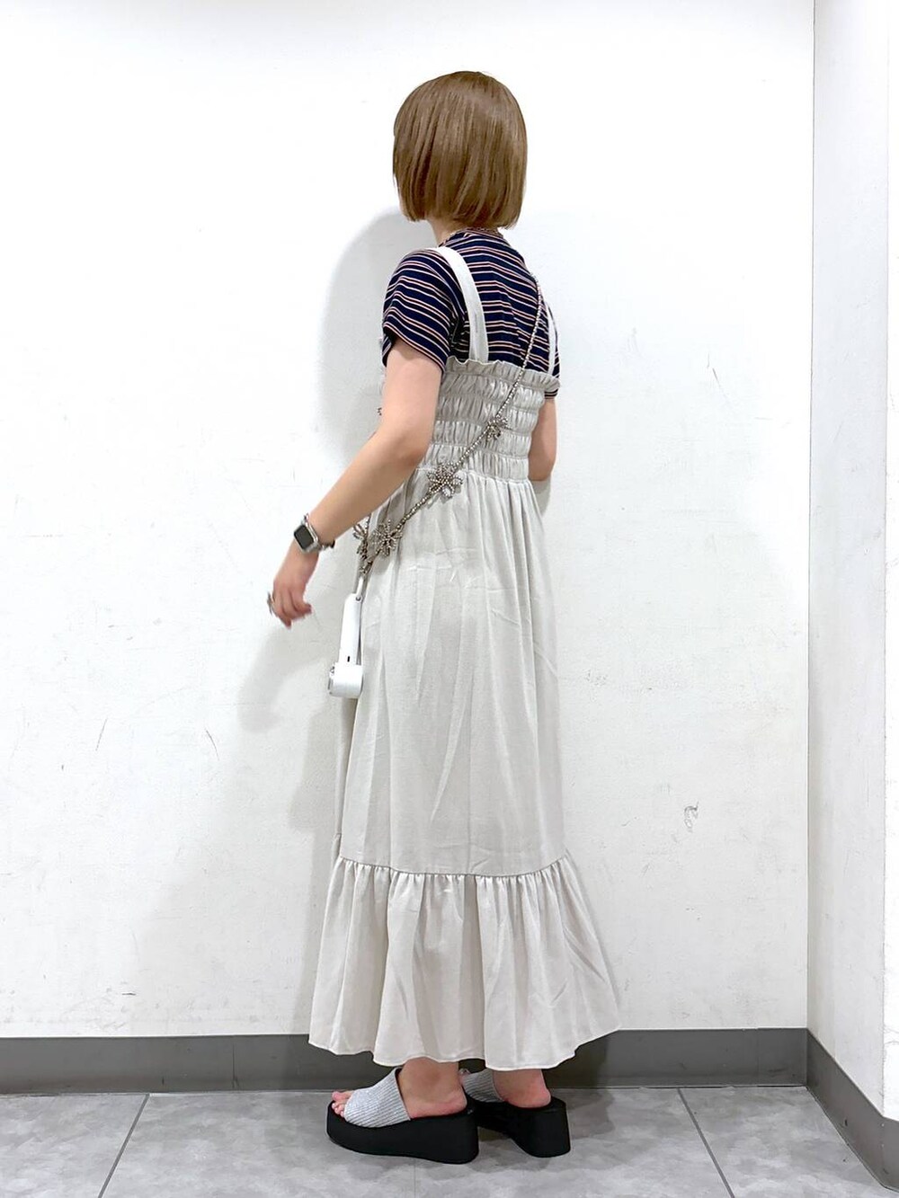 ホワイト系のワンピース、シルバー系のサンダル、ブラウン系のTシャツ/カットソーを着用したレディースの夏コーディネートの3枚目の写真