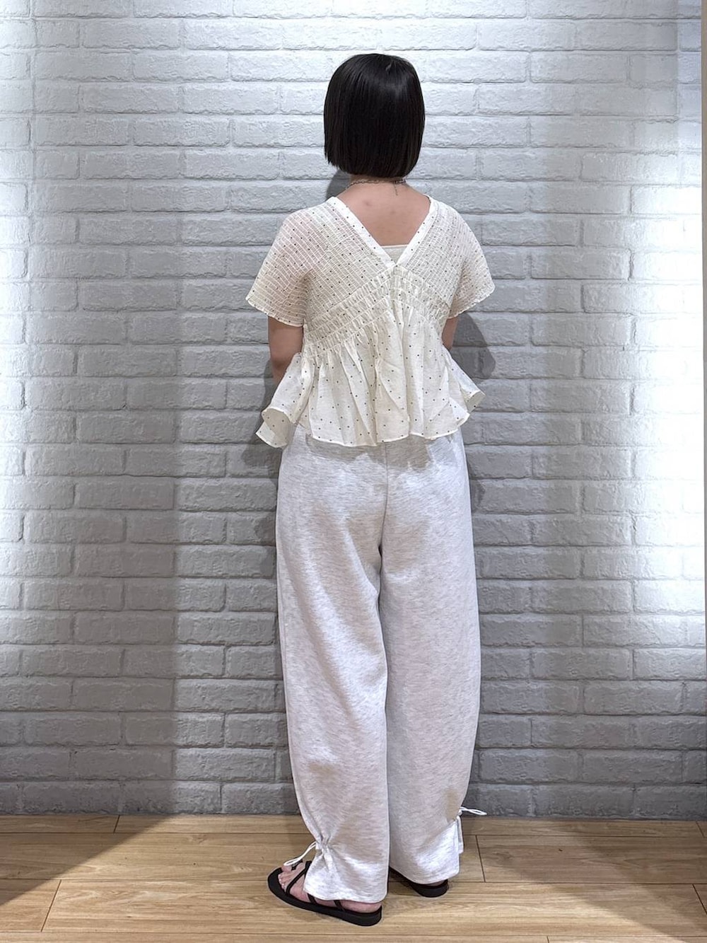 グレー系のスウェットパンツ、ゴールド系のタンクトップ、ブラック系のサンダルを着用したレディースの夏コーディネートの3枚目の写真