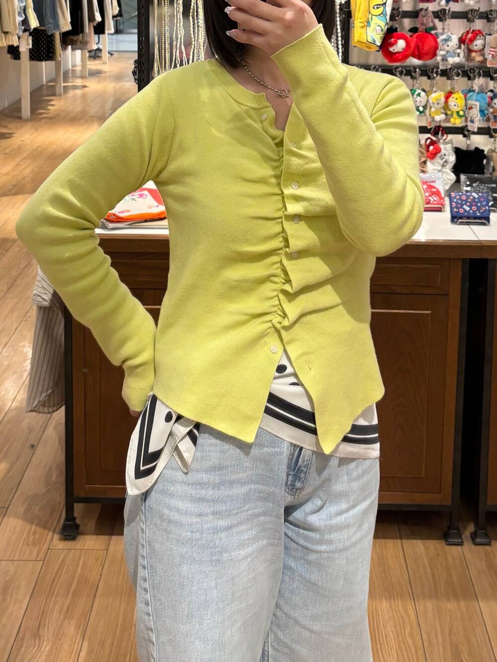 ブルー系のデニムパンツ、ブラウン系のローファー、イエロー系のカーディガン/ボレロを着用したレディースの春コーディネートの2枚目の写真