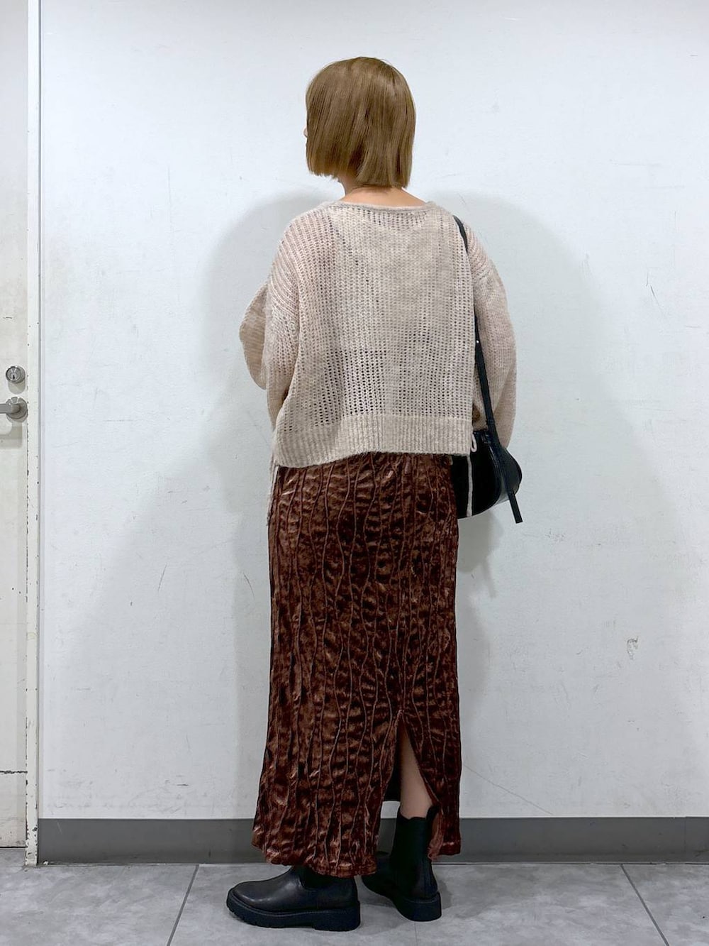 ブラック系のショルダーバッグ、ブラウン系のワンピース、ホワイト系のニット/セーターを着用したレディースの秋コーディネートの3枚目の写真