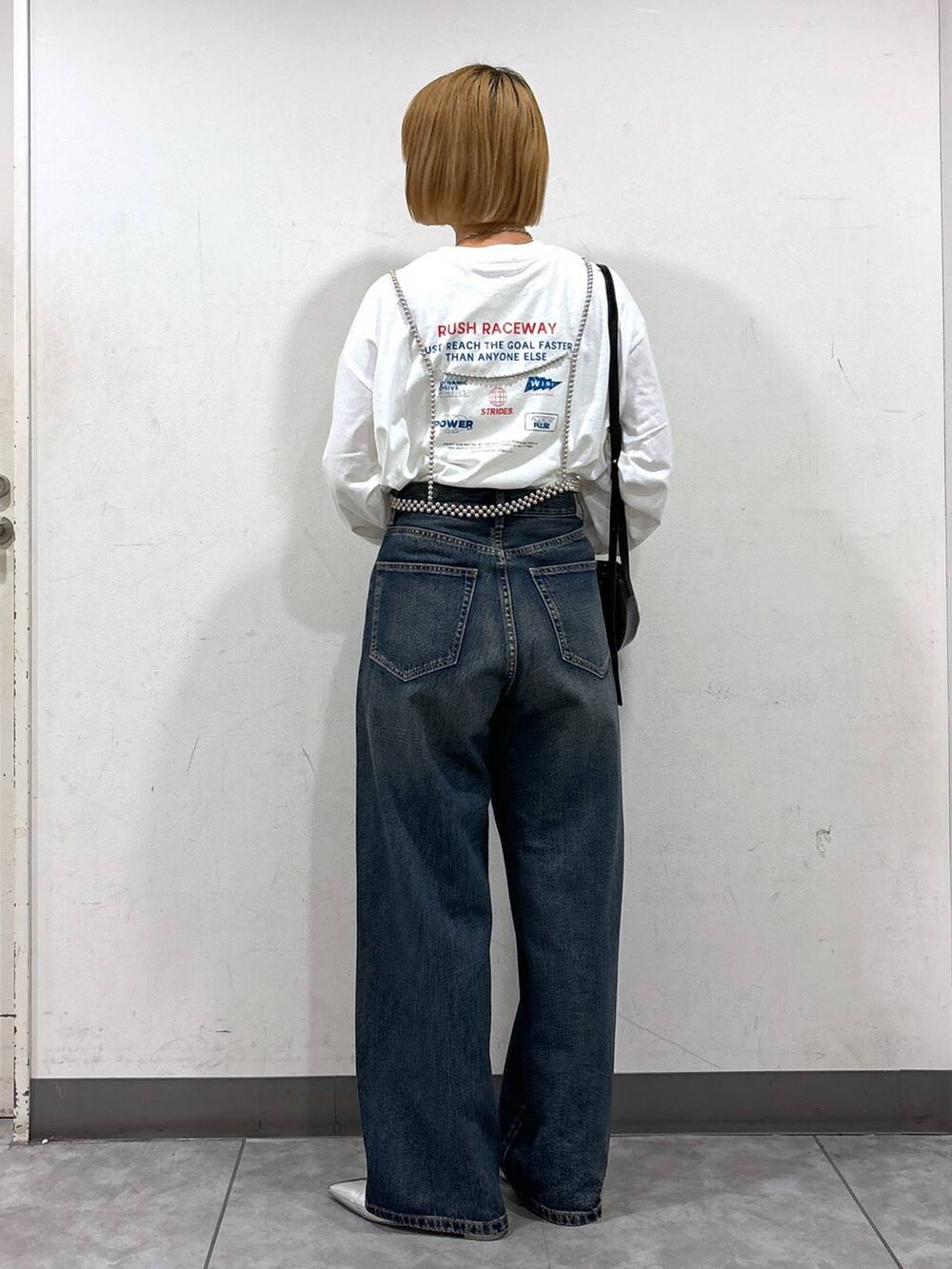 シルバー系のパンプス、ホワイト系のTシャツ/カットソー、ブルー系のデニムパンツを着用したレディースの秋コーディネートの3枚目の写真