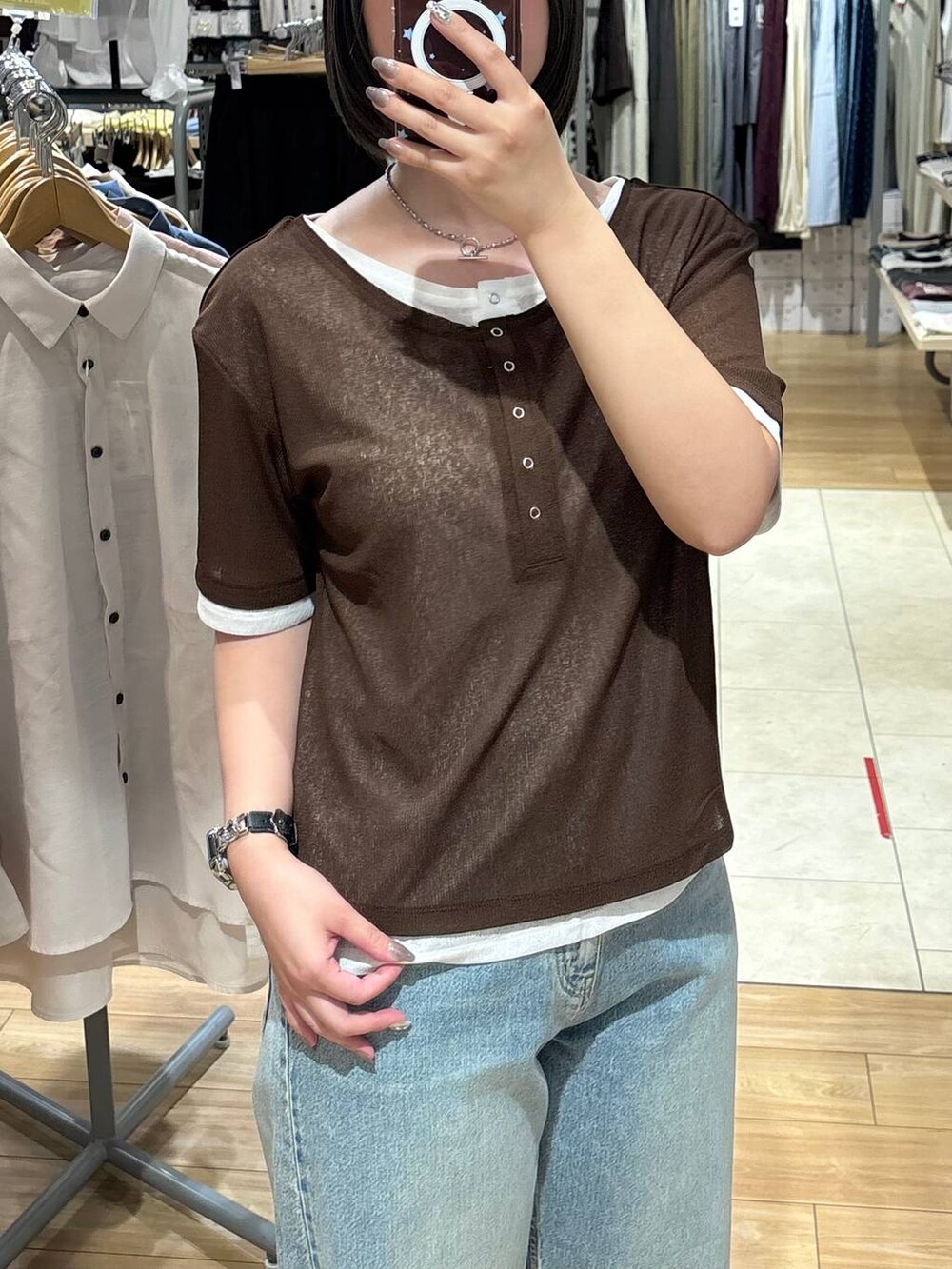 ブルー系のデニムパンツ、ブラック系のサンダル、ブラウン系のTシャツ/カットソーを着用したレディースの夏コーディネートの2枚目の写真