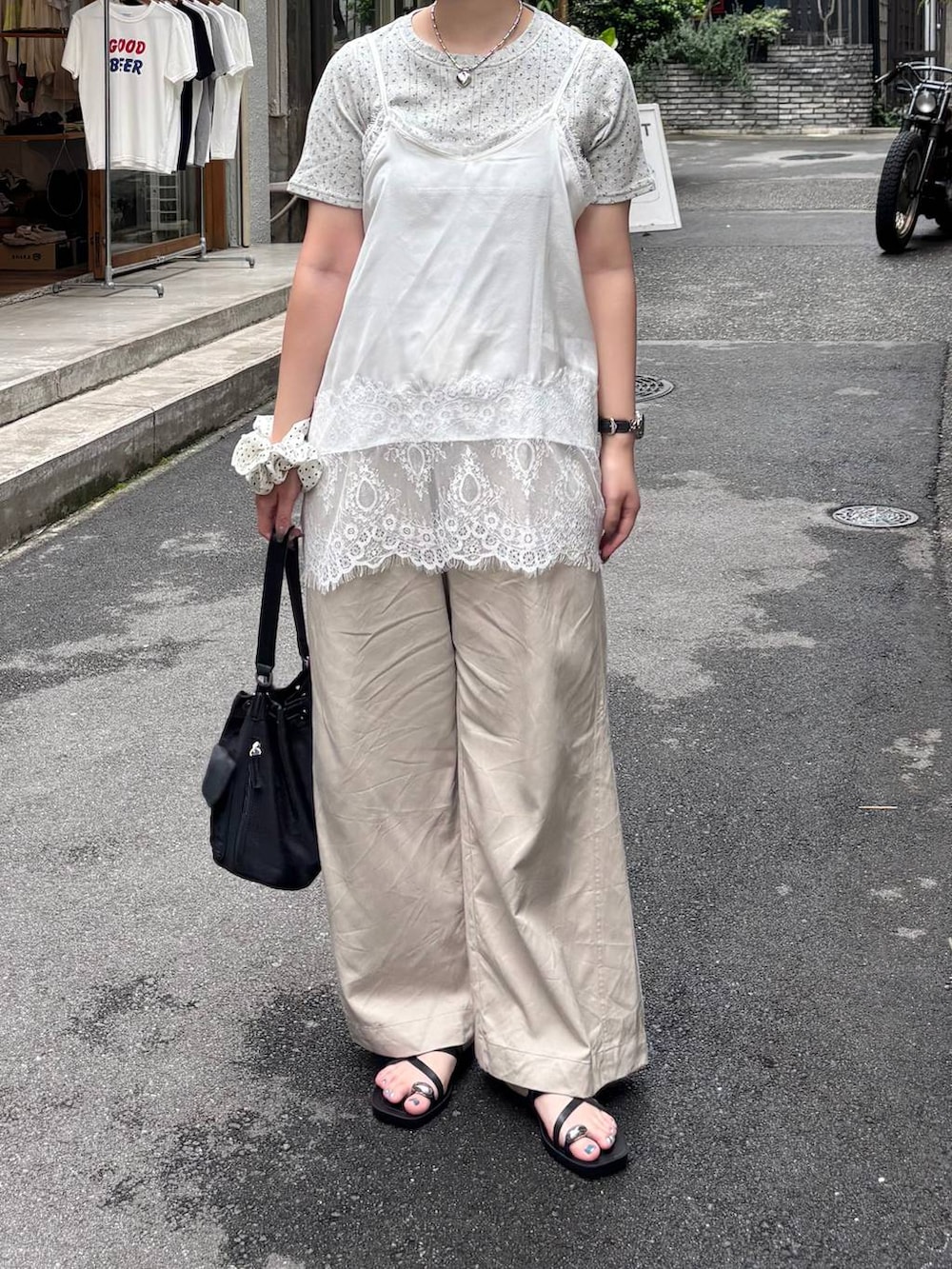 ベージュ系のデニムパンツ、ブラック系のサンダル、ホワイト系のTシャツ/カットソーを着用したレディースの夏コーディネートの3枚目の写真