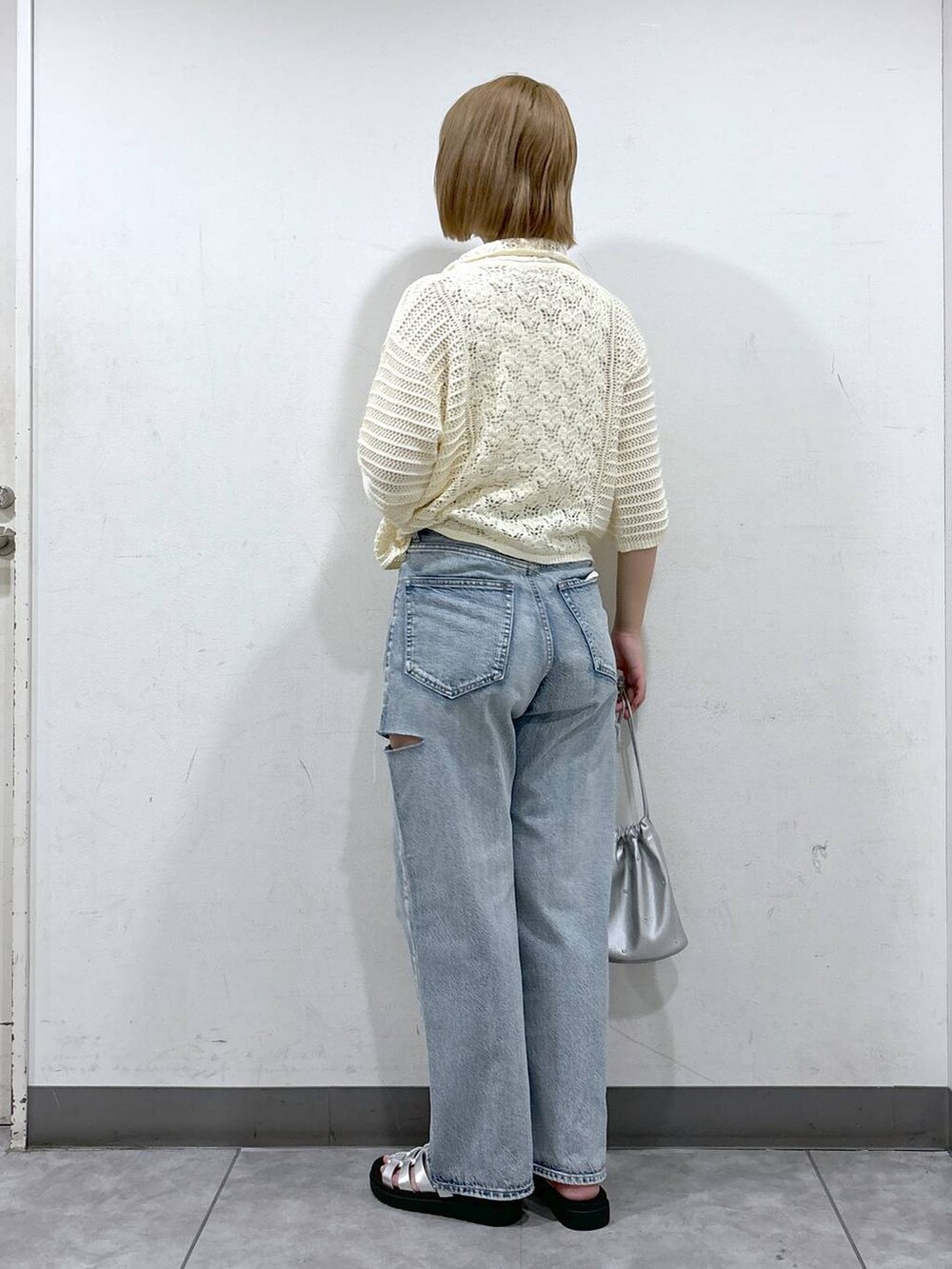 シルバー系のショルダーバッグ、ホワイト系のニット/セーター、シルバー系のスニーカーを着用したレディースの夏コーディネートの3枚目の写真