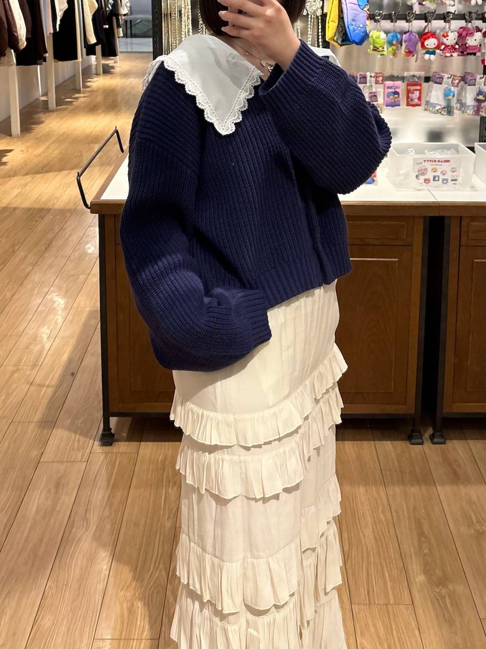 ブラック系のローファー、ホワイト系のスカート、ブルー系のカーディガン/ボレロを着用したレディースの冬コーディネートの2枚目の写真