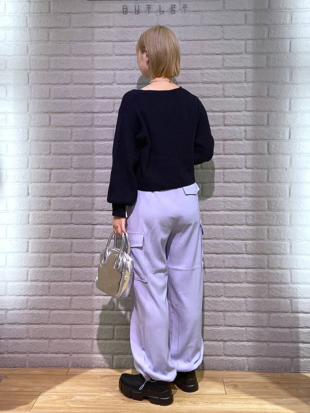 ホワイト系のタンクトップ、ブラック系のブーツ、ブラック系のカーディガン/ボレロを着用したレディースの秋コーディネートの3枚目の写真