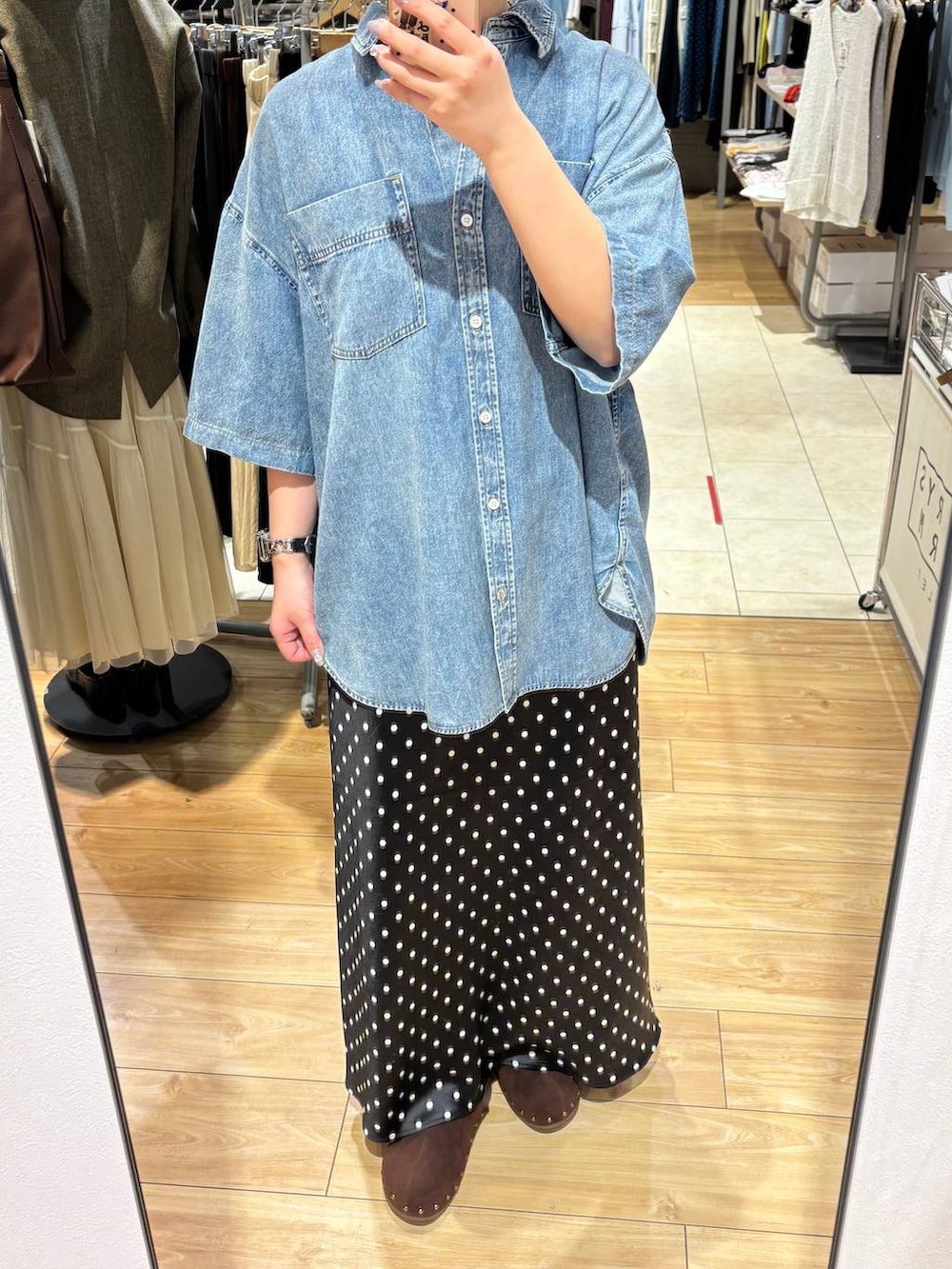 ブラック系のスカート、ブラウン系のサンダル、ブルー系のシャツ/ブラウスを着用したレディースの春コーディネートの3枚目の写真