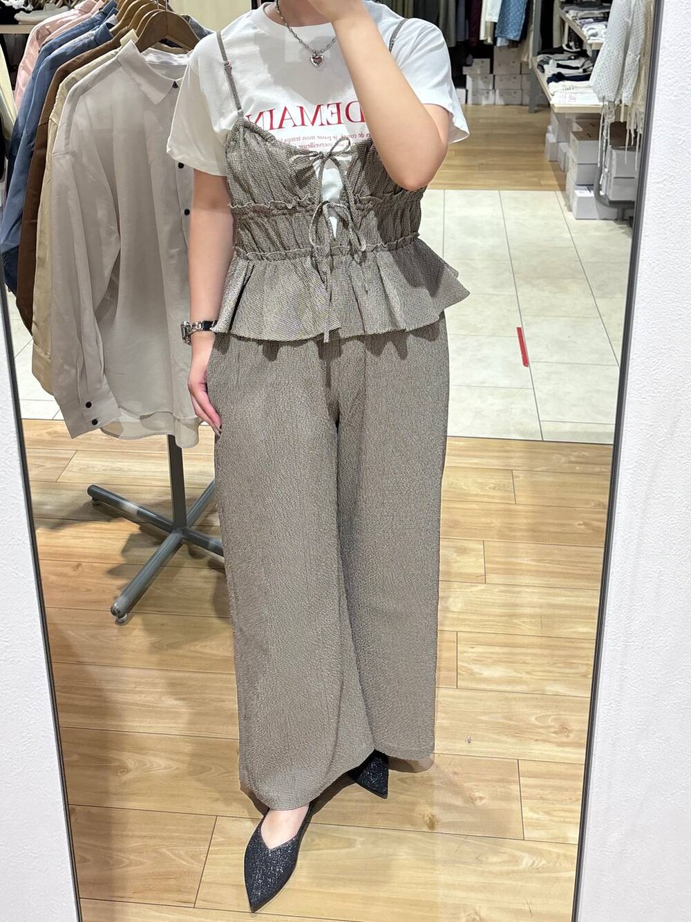 ブラック系のパンプス、ホワイト系のTシャツ/カットソー、ブラウン系のサロペット/オーバーオールを着用したレディースの春コーディネートの3枚目の写真
