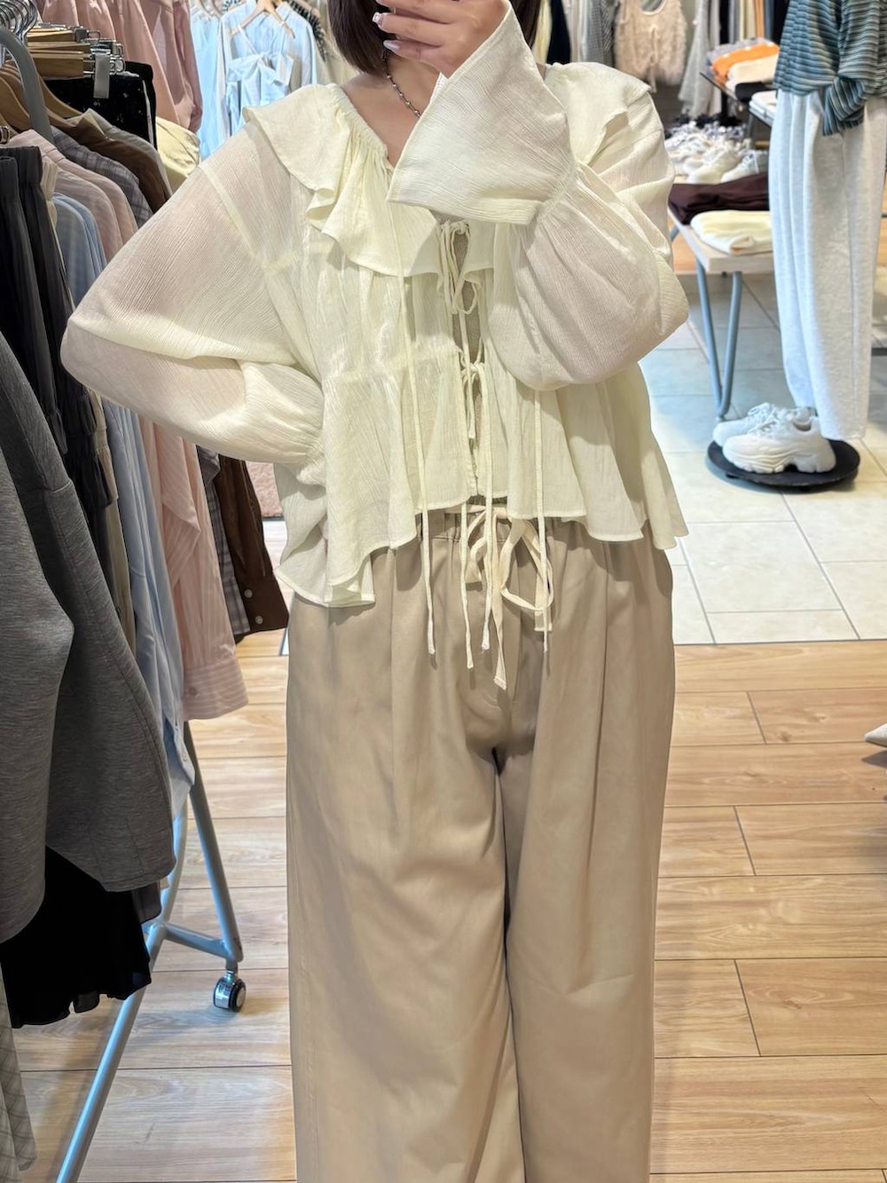 シルバー系のタンクトップ、ベージュ系のデニムパンツ、ホワイト系のシャツ/ブラウスを着用したレディースの春コーディネートの2枚目の写真