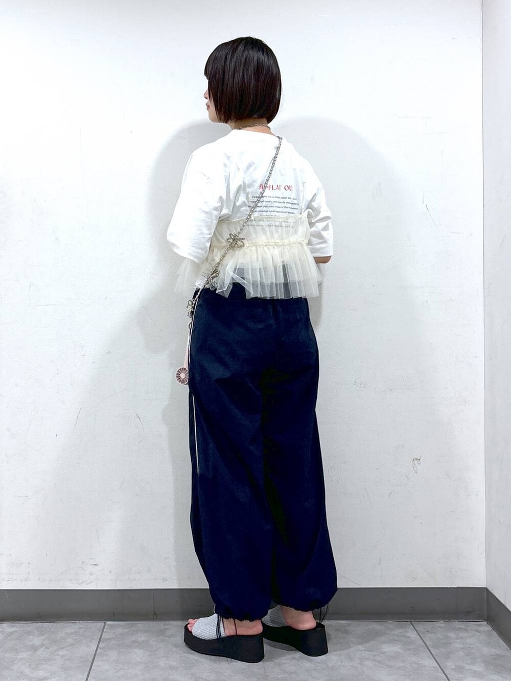 シルバー系のサンダル、ホワイト系のベスト、ホワイト系のTシャツ/カットソーを着用したレディースの夏コーディネートの3枚目の写真