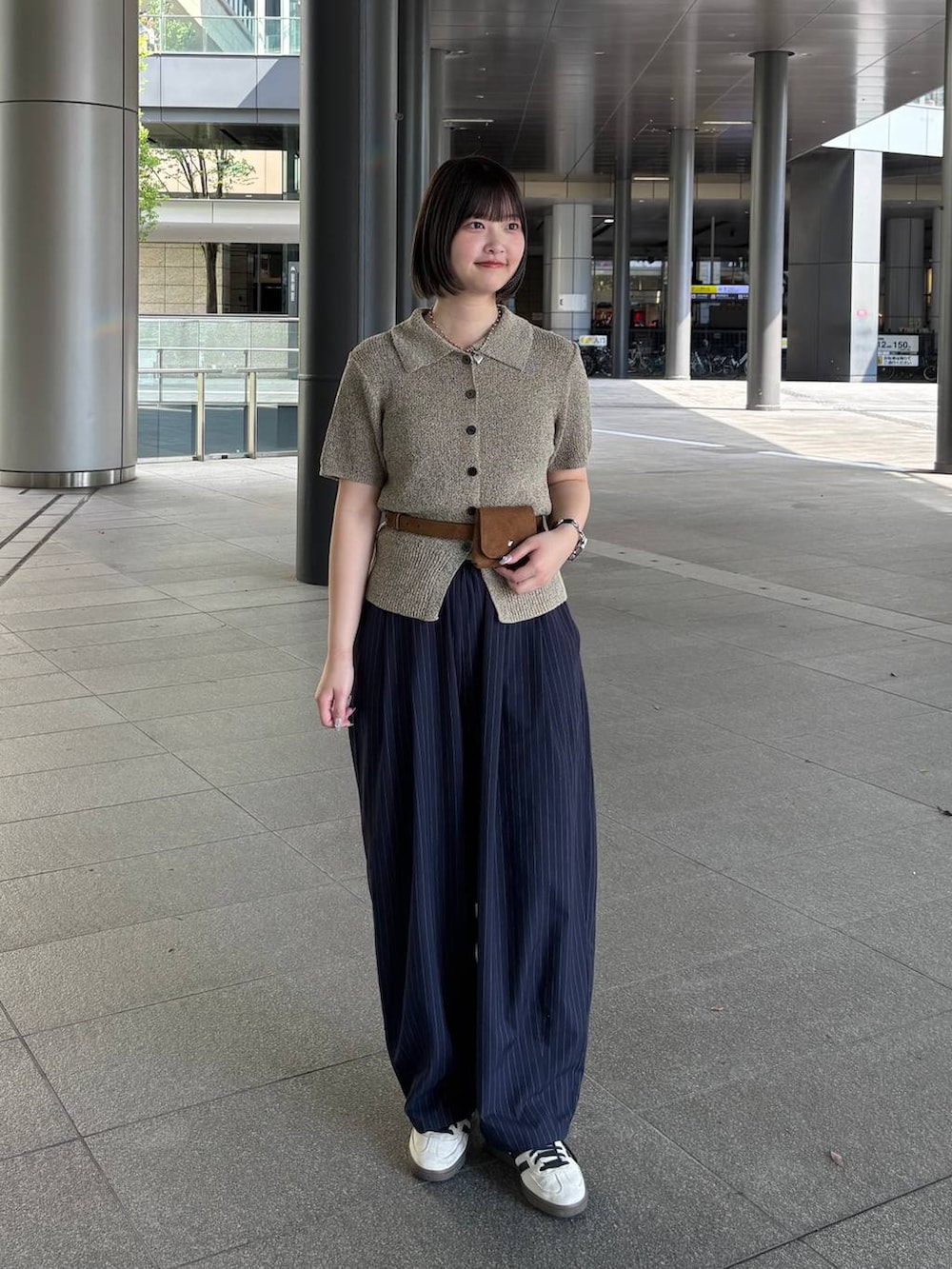 ブルー系のその他パンツ、ベージュ系のTシャツ/カットソー、イエロー系のベルトを着用したレディースの春コーディネートの2枚目の写真