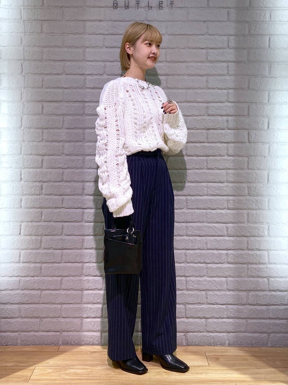 ブルー系のその他パンツ、ブラック系のパンプス、ブラック系のショルダーバッグを着用したレディースの秋コーディネートの2枚目の写真