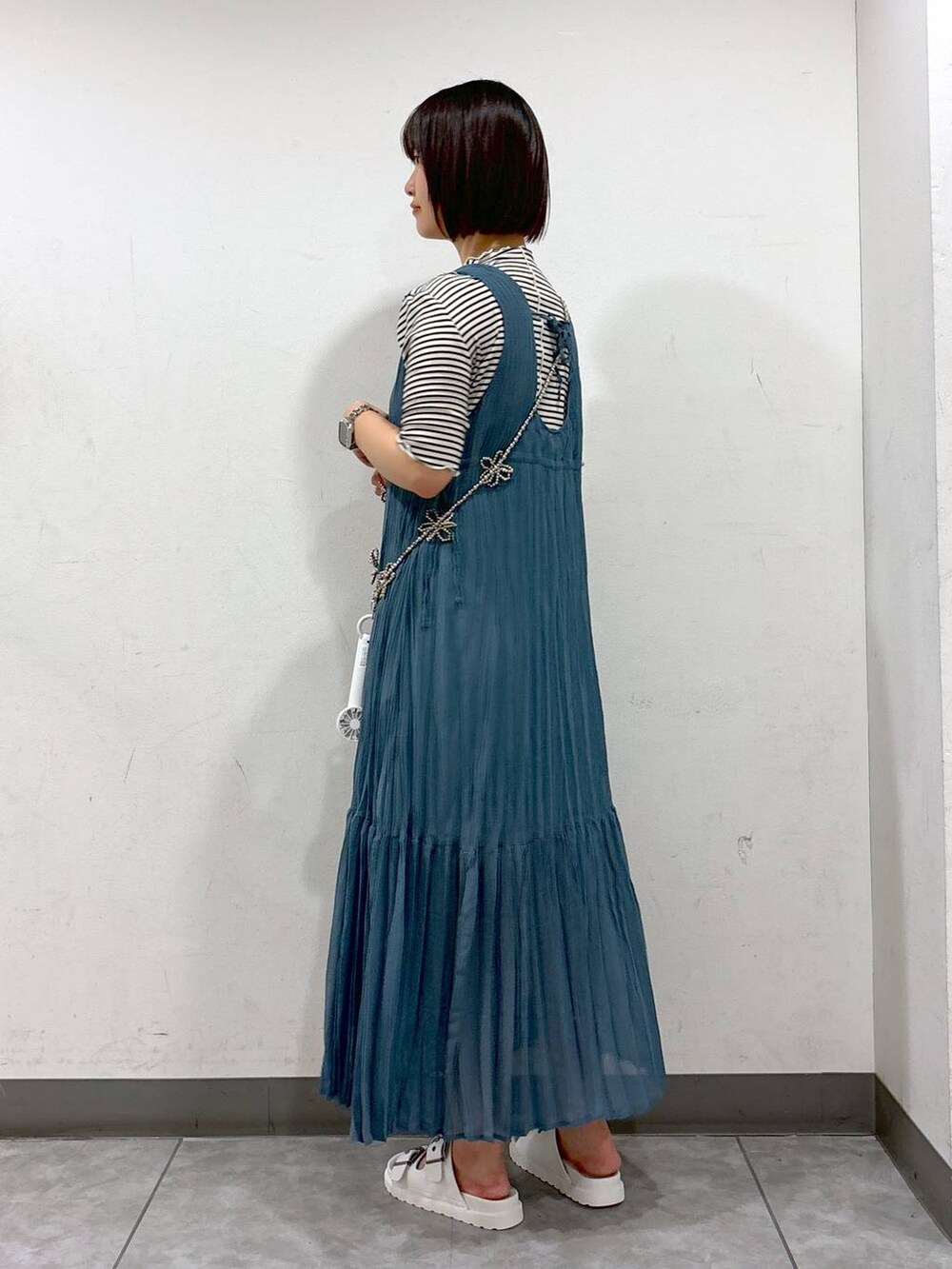 ブルー系のワンピース、ホワイト系のTシャツ/カットソー、ホワイト系のサンダルを着用したレディースの夏コーディネートの3枚目の写真