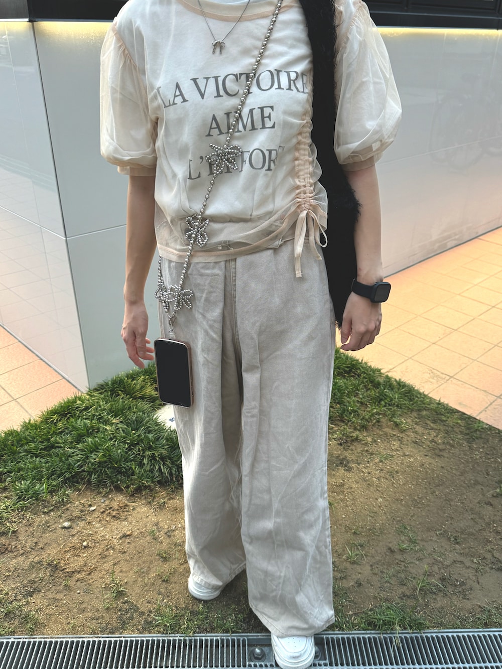 ブラック系のトートバッグ、ベージュ系のデニムパンツ、ホワイト系のTシャツ/カットソーを着用したレディースの夏コーディネートの2枚目の写真
