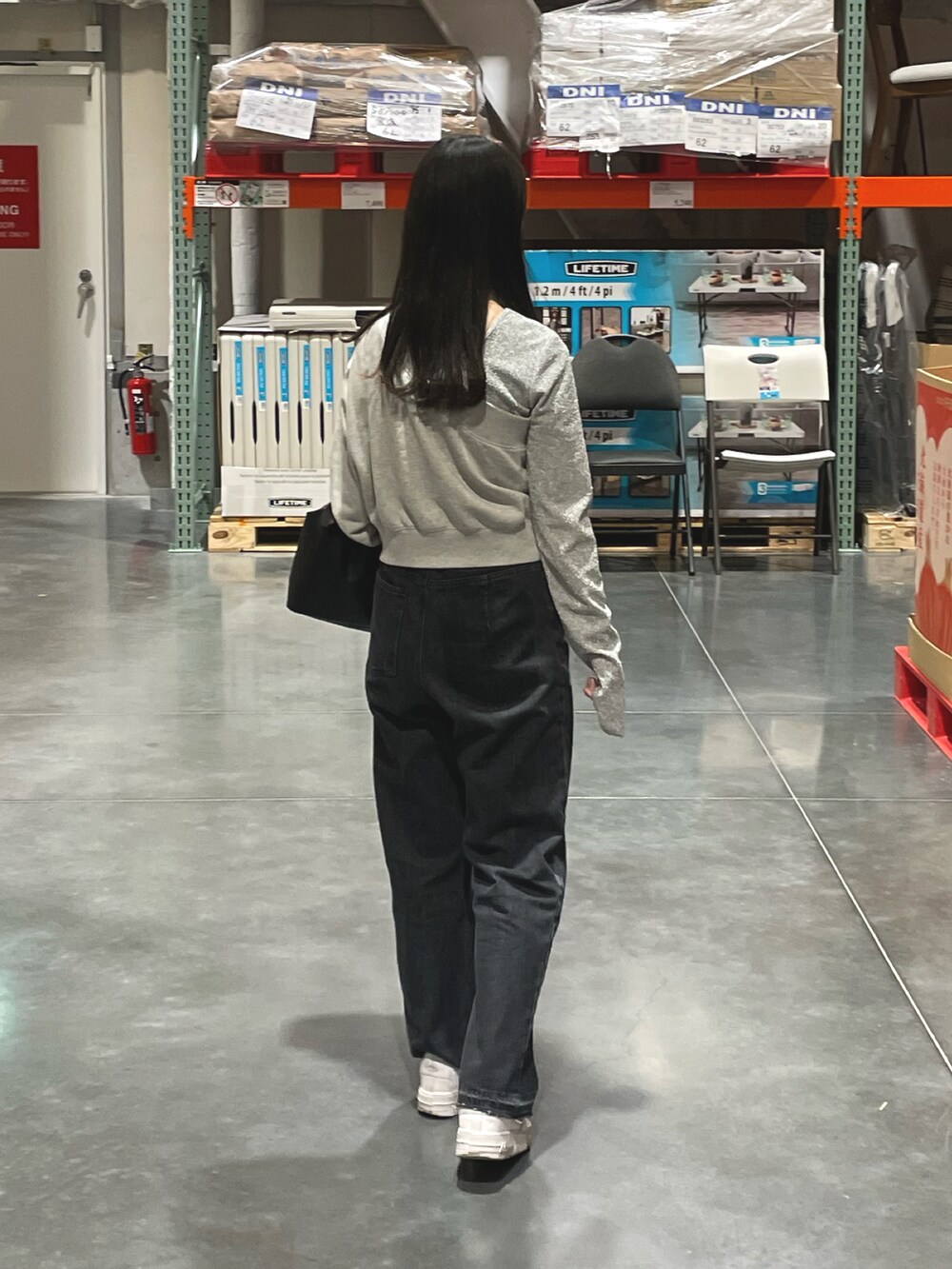 ブラック系のハンドバッグ、ブラック系のデニムパンツ、シルバー系のTシャツ/カットソーを着用したレディースの春コーディネートの2枚目の写真
