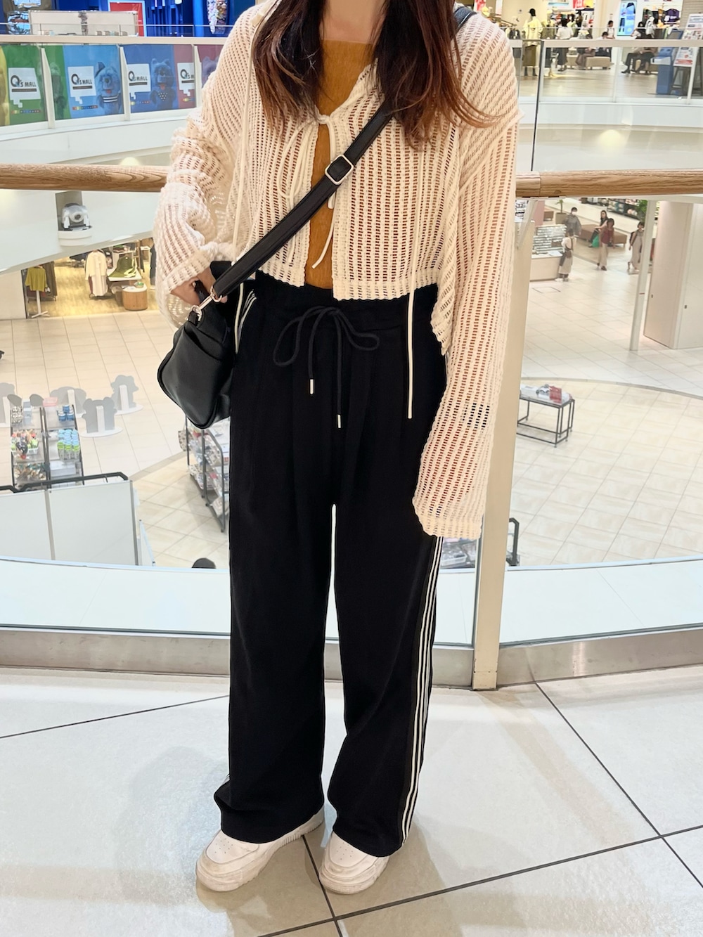 ブラック系のその他パンツ、ブラック系のショルダーバッグ、ホワイト系のカーディガン/ボレロを着用したレディースの秋コーディネートの2枚目の写真