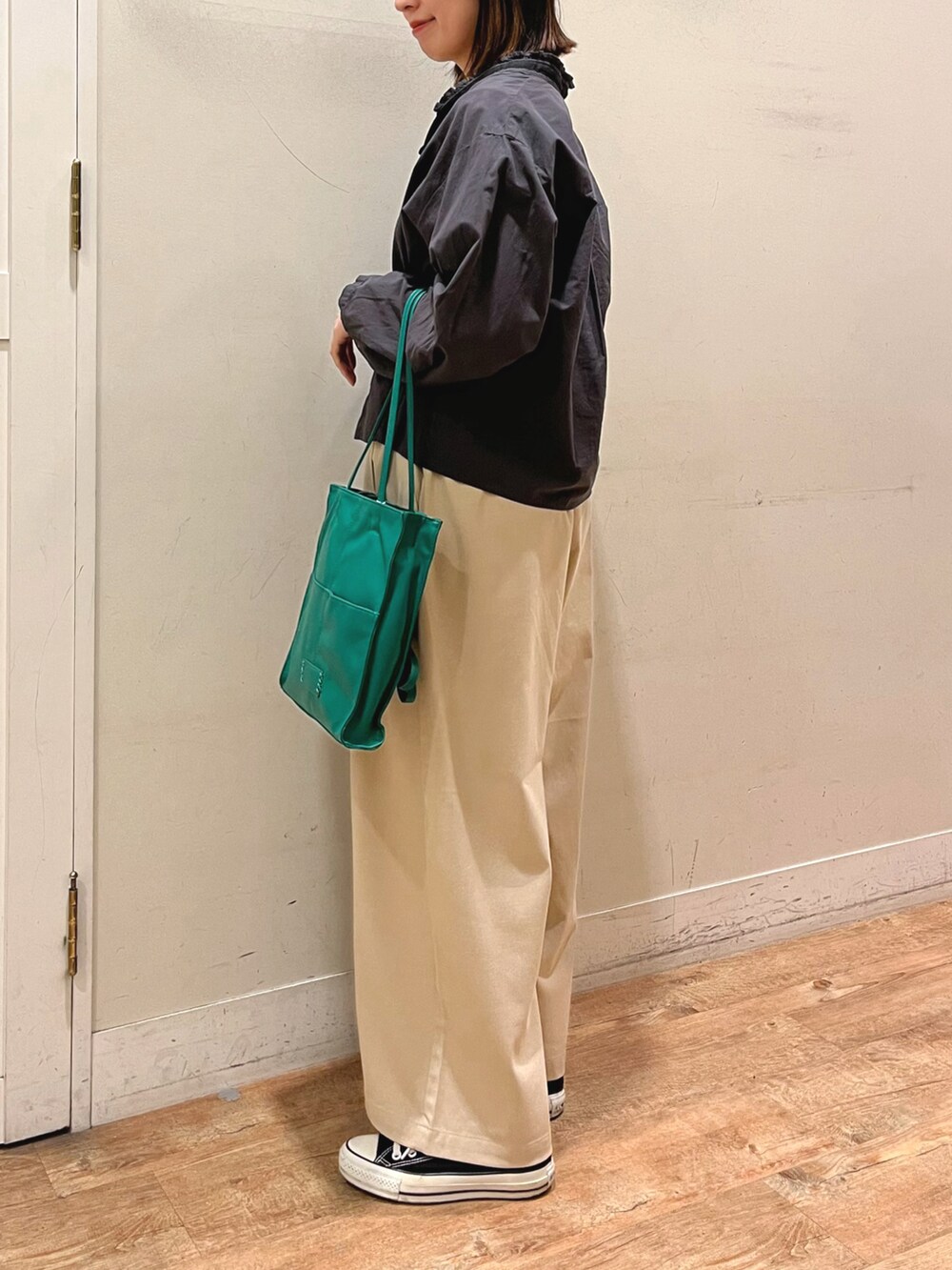グリーン系のバッグを着用したレディースの春コーディネートの2枚目の写真