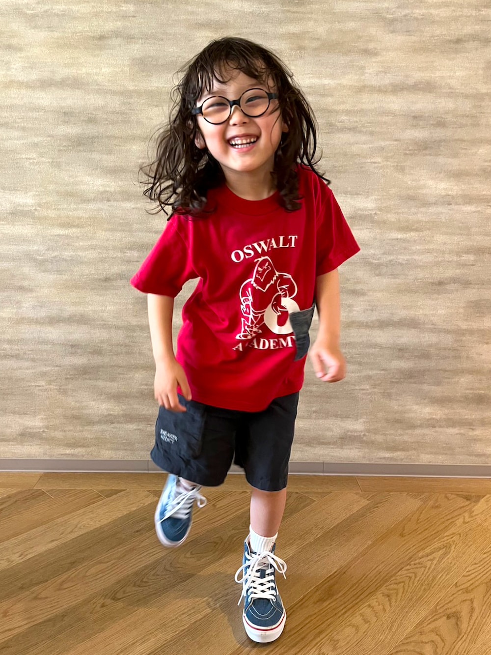 レッド系のTシャツ/カットソー、ブルー系のスニーカー、ブラック系のその他パンツを着用したメンズの秋コーディネートの2枚目の写真