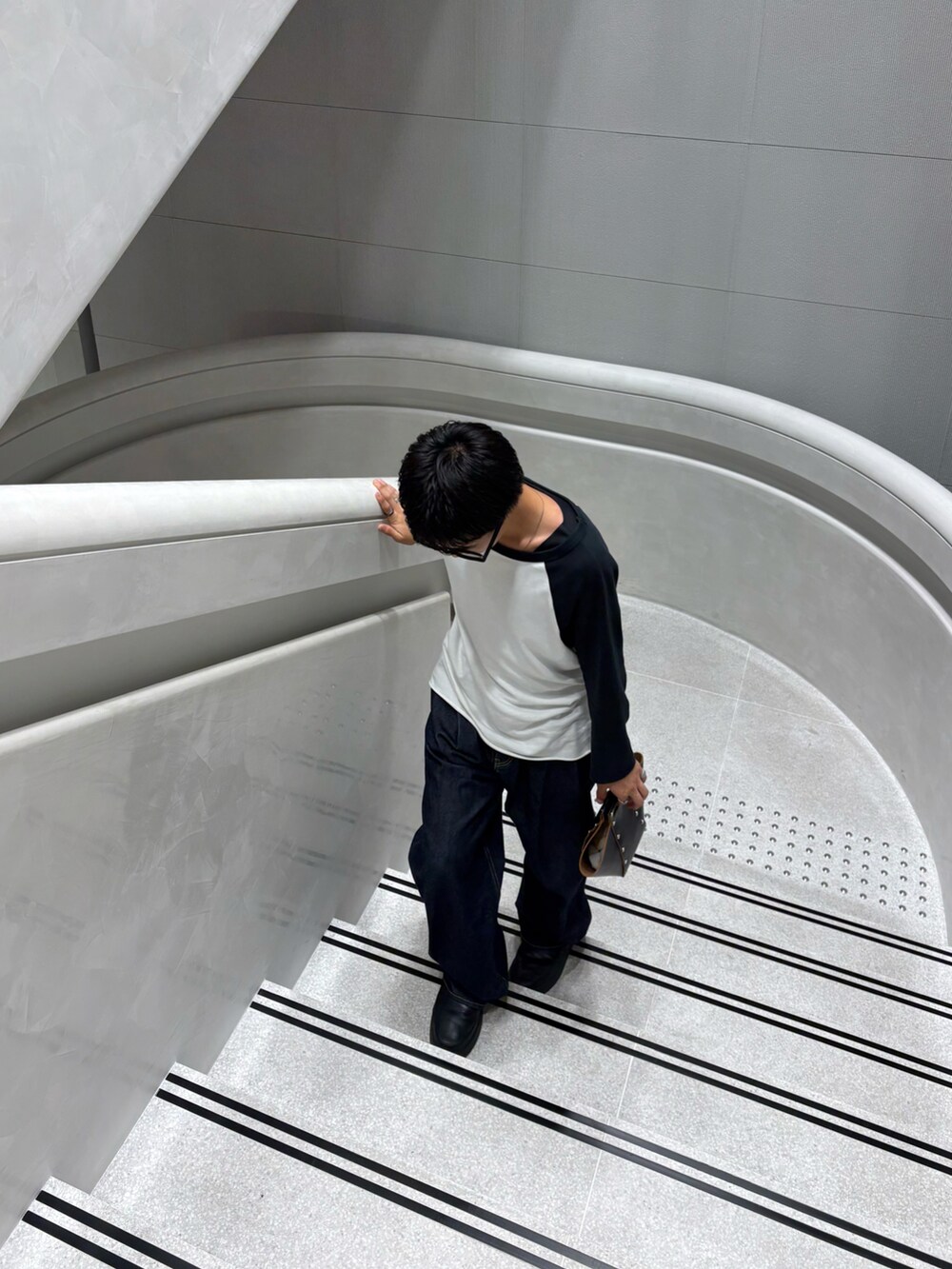 ブルー系のパンツ、ホワイト系のトップスを着用したメンズの秋コーディネートの5枚目の写真