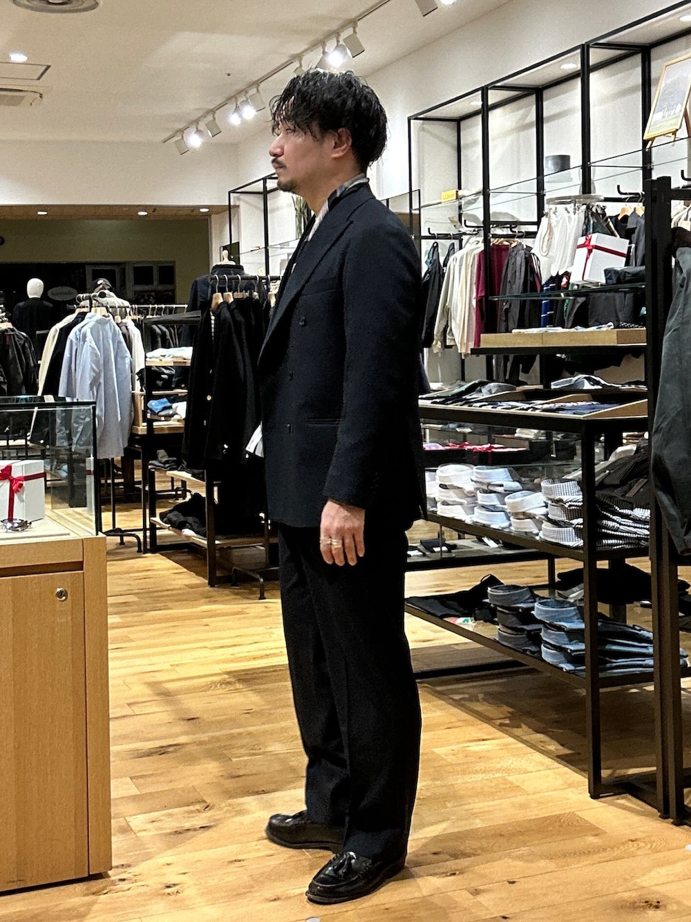 ブルー系のスーツパンツ、ブルー系のその他アウター、ホワイト系のニット/セーターを着用したメンズの冬コーディネートの2枚目の写真