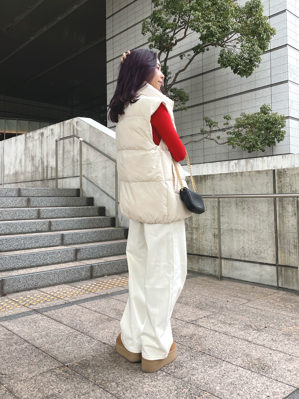 ホワイト系のデニムパンツ、ホワイト系のダウンベスト、ベージュ系のその他シューズを着用したレディースの冬コーディネートの2枚目の写真