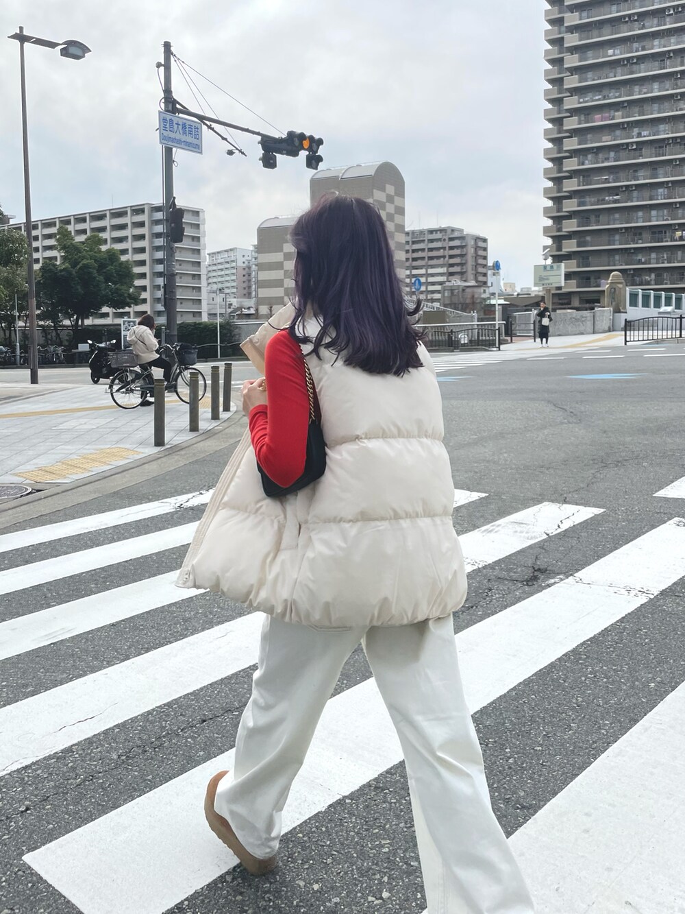 ホワイト系のデニムパンツ、ホワイト系のダウンベスト、ベージュ系のその他シューズを着用したレディースの冬コーディネートの3枚目の写真