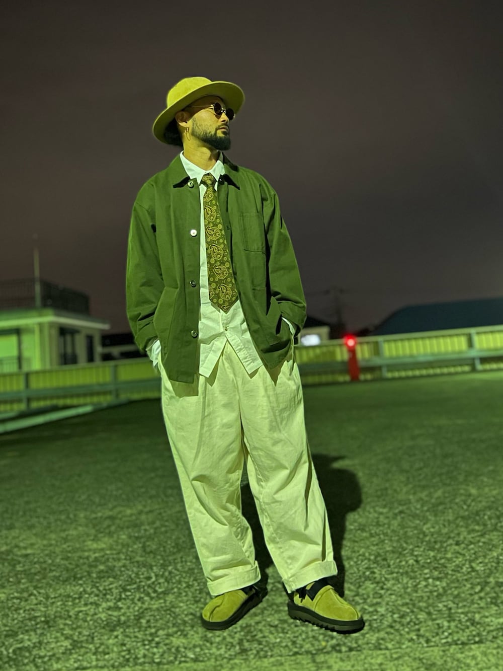 グリーン系のミリタリージャケット、グリーン系のネクタイ、ベージュ系のサンダルを着用したメンズの春コーディネートの2枚目の写真