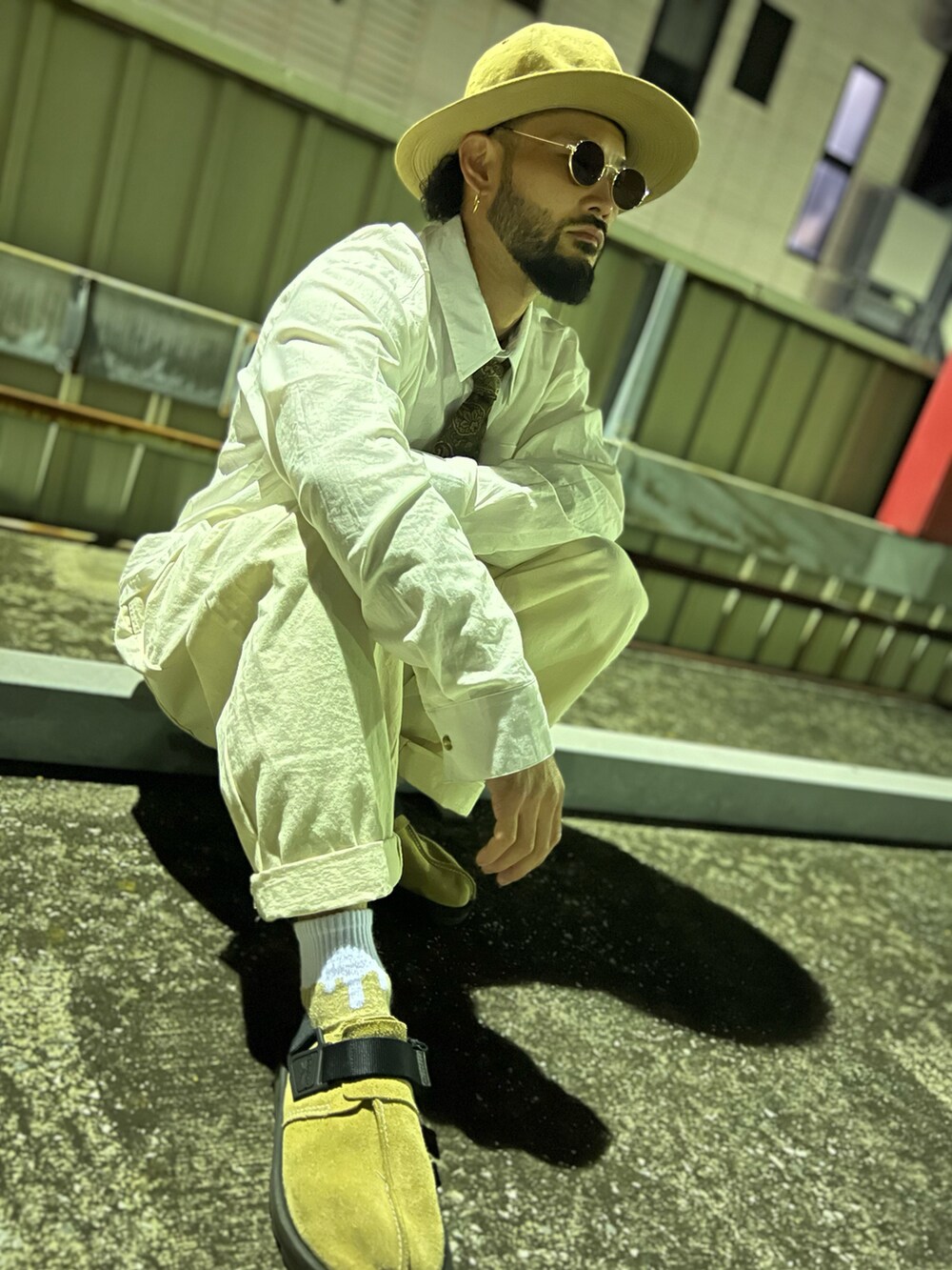 グリーン系のミリタリージャケット、グリーン系のネクタイ、ベージュ系のサンダルを着用したメンズの春コーディネートの4枚目の写真