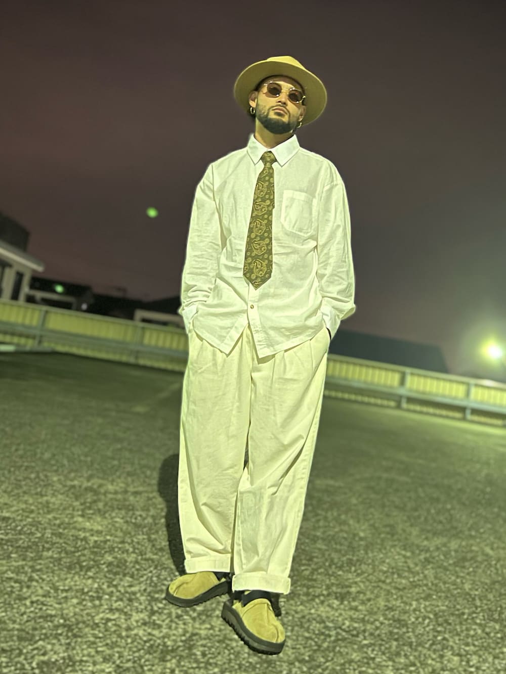 グリーン系のミリタリージャケット、グリーン系のネクタイ、ベージュ系のサンダルを着用したメンズの春コーディネートの3枚目の写真