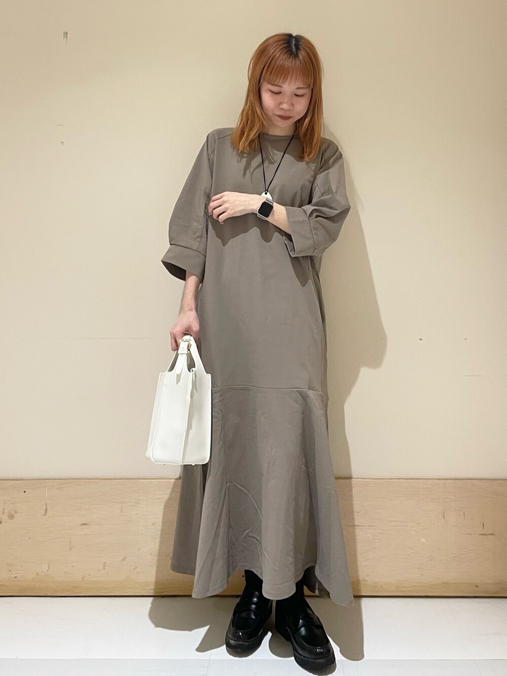 ブラウン系のワンピース、ホワイト系のトートバッグ、ブラック系のローファーを着用したレディースの春コーディネートの3枚目の写真