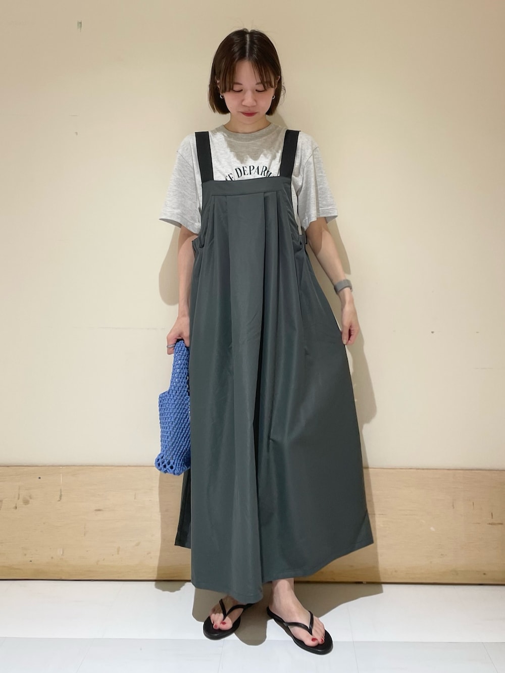 グレー系のワンピース、ブラック系のサンダル、ブルー系のハンドバッグを着用したレディースの夏コーディネートの2枚目の写真